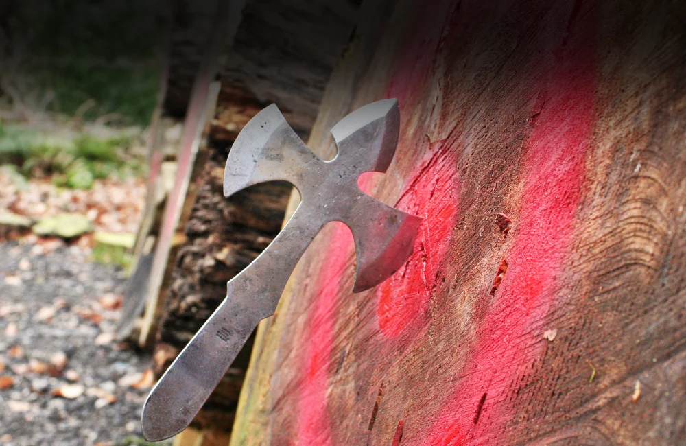 Throwing angel knife stuck in the bullseye of a large wooden target at Adventure Now