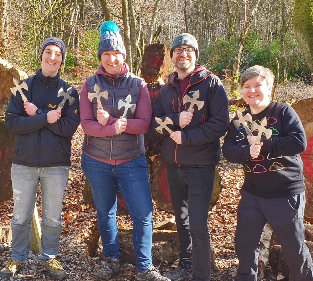 Group of smiling friends smiling whilst holding throwing knives