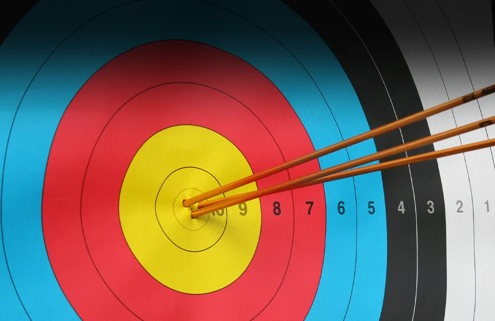 Archery target with three arrows stuck into the bullseye