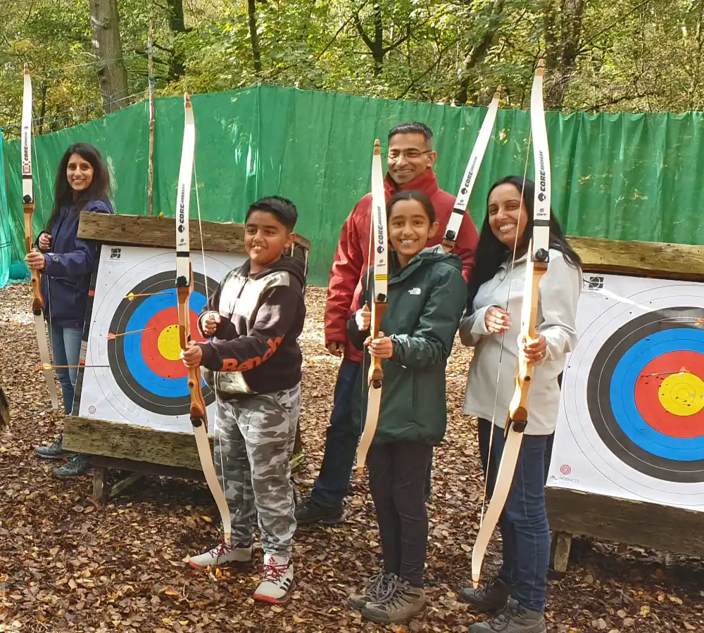 Happy family group posing with archery bows and targets