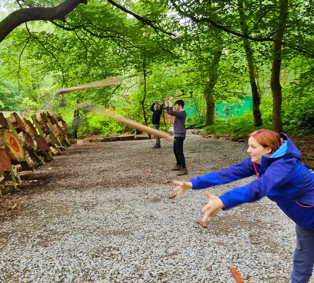 Action shot of two throwing axes mid-air thrown by a lady