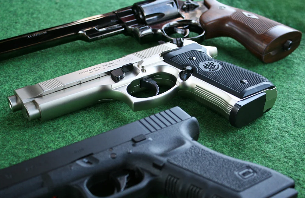 Closeup photo of a Glock 17, Beretta M92 and Smith and Wesson M29 air pistols at Adventure Now Manchester