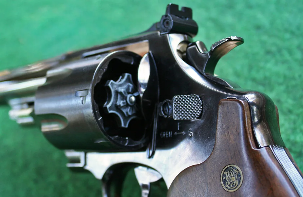 Closeup of a six-shooter showing the cylinder, safety catch, hammer and Smith and Wesson logo