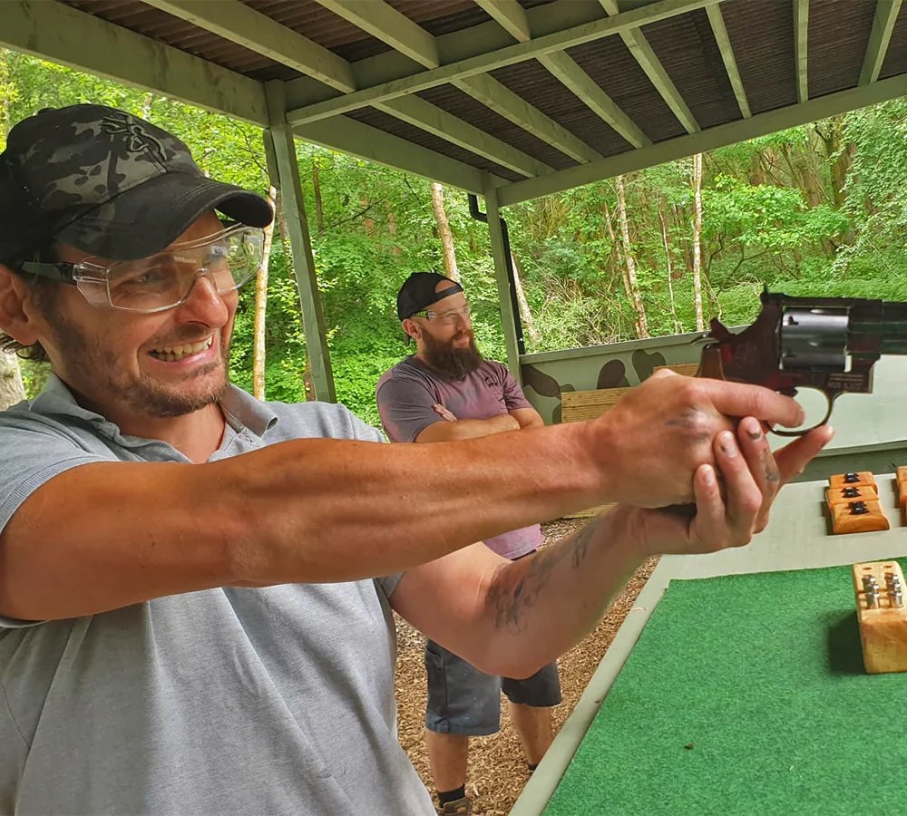 Excited man aiming and firing a revolver pistol. Pistol bullets shown in background