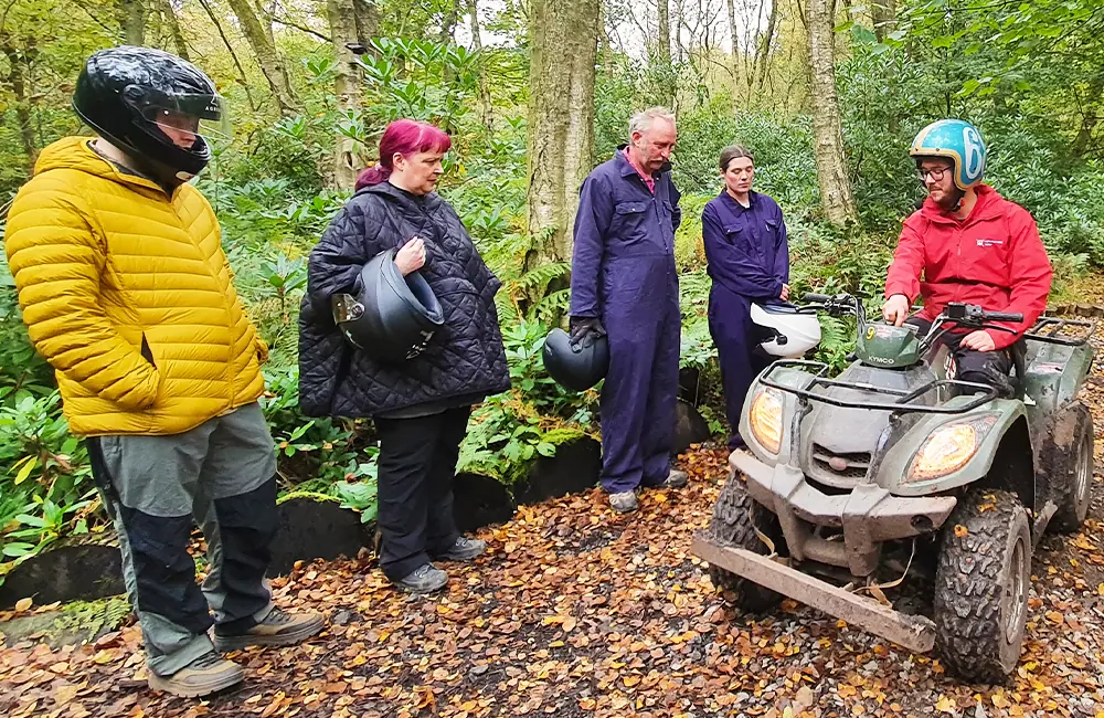 Four people and an instructor on a quad bike training day at Adventure Now Manchester