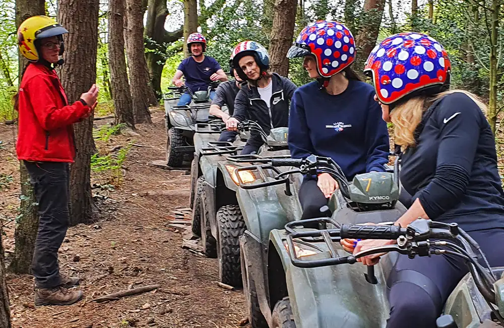 Instructor talking to several participants on quad bikes