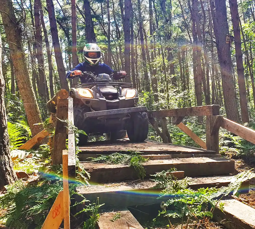 Person driving an ATV on a raised platform