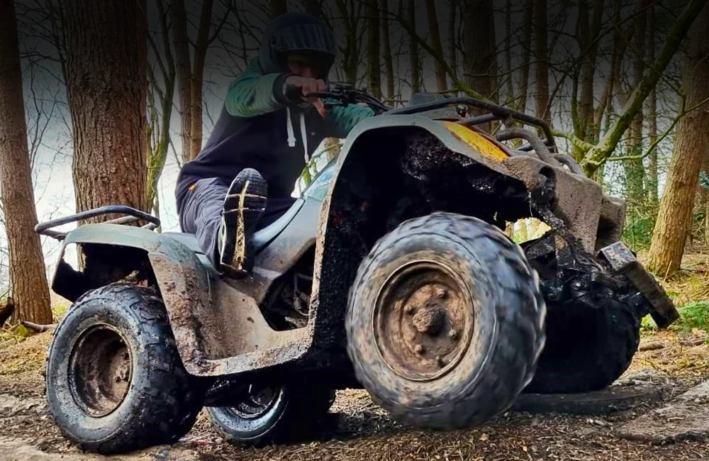 Action shot of a Quad Biking on three wheels with the rider leaning back