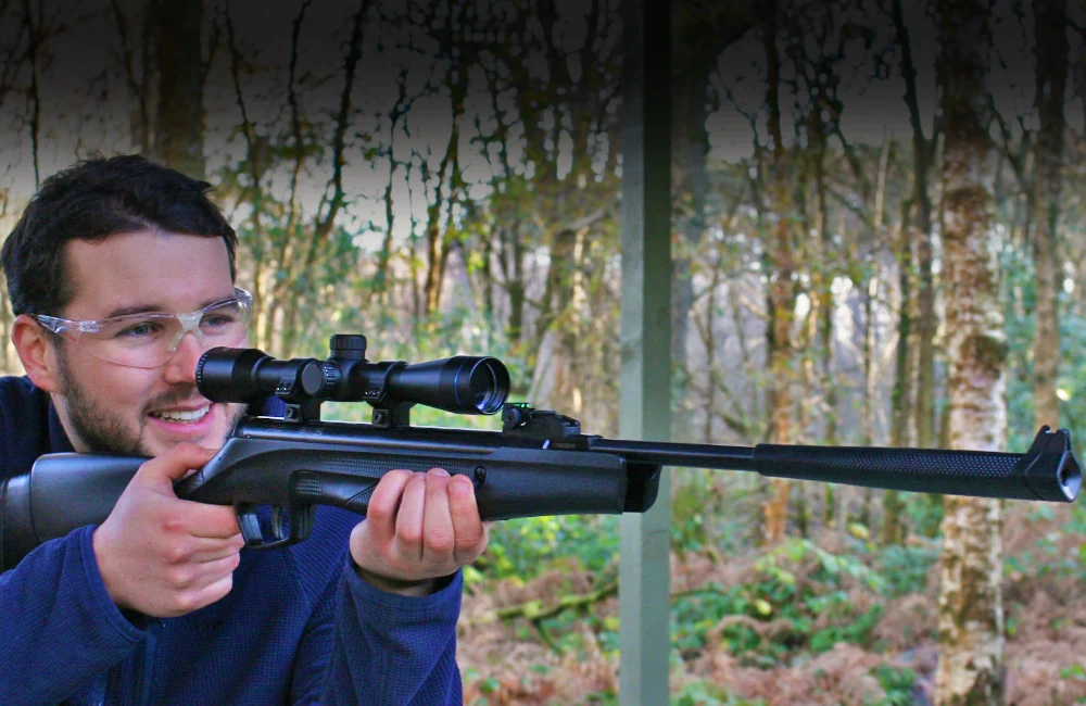 Smiling man aiming a Beretta air rifle with a telescopic scope