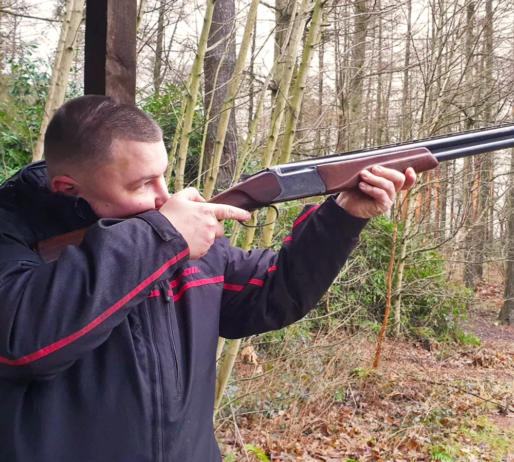 Man posing with shotgun in a firing position