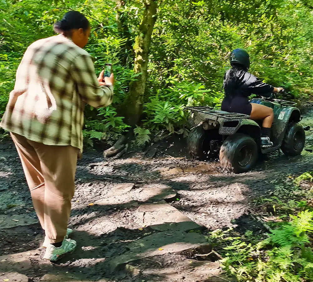 Manchester influencer filming quad bike driving in a green summer woodland