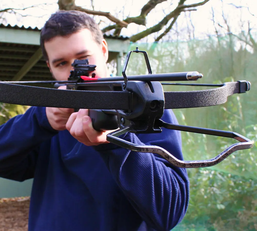 Person holding and aiming crossbow for a photo-shoot