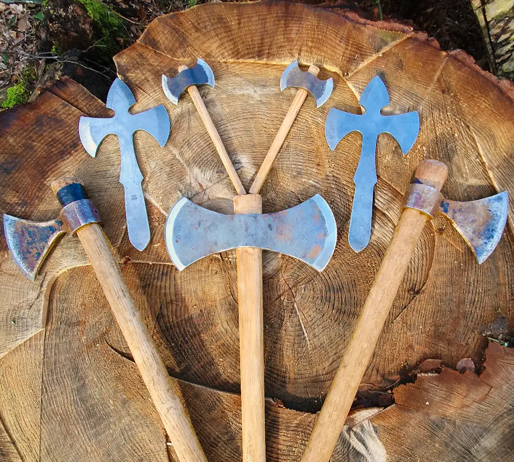 Selection of throwing axes and knives on a wooden background