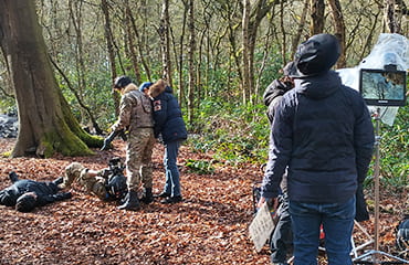 Outdoor combat scene filming with director monitor and helmet camera