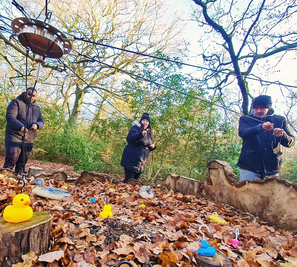 Team of people working together to hook rubber ducks as part of a corporate activity day