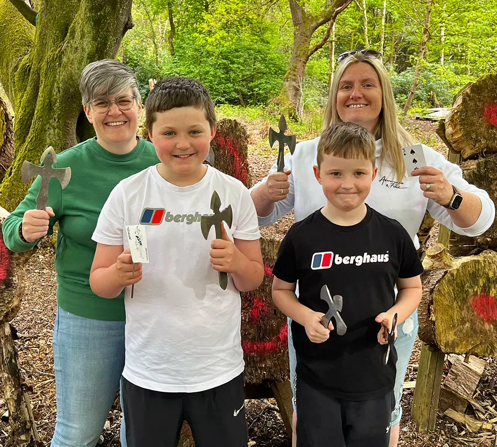 Smiling family group stood holding throwing angels at Adventure Now Manchester