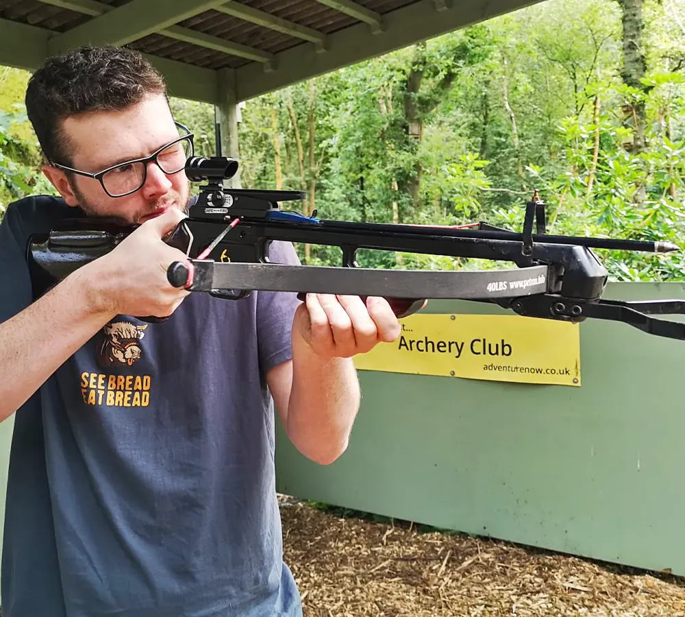 Man concentrating whilst aiming a crossbow on a session at Adventure Now in Manchester