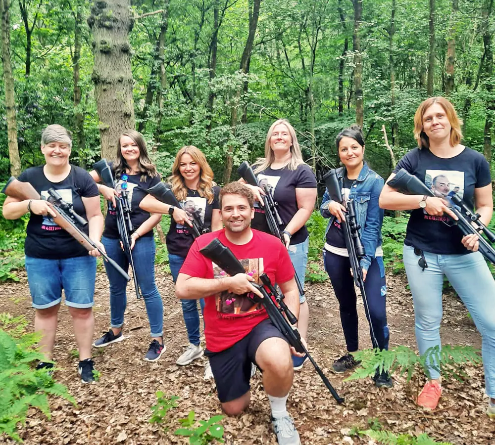 Hen group posing together with air rifles after shooting them as one of their activities