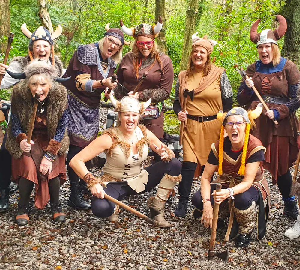 Hen do group dressed as vikings doing axe throwing outdoors