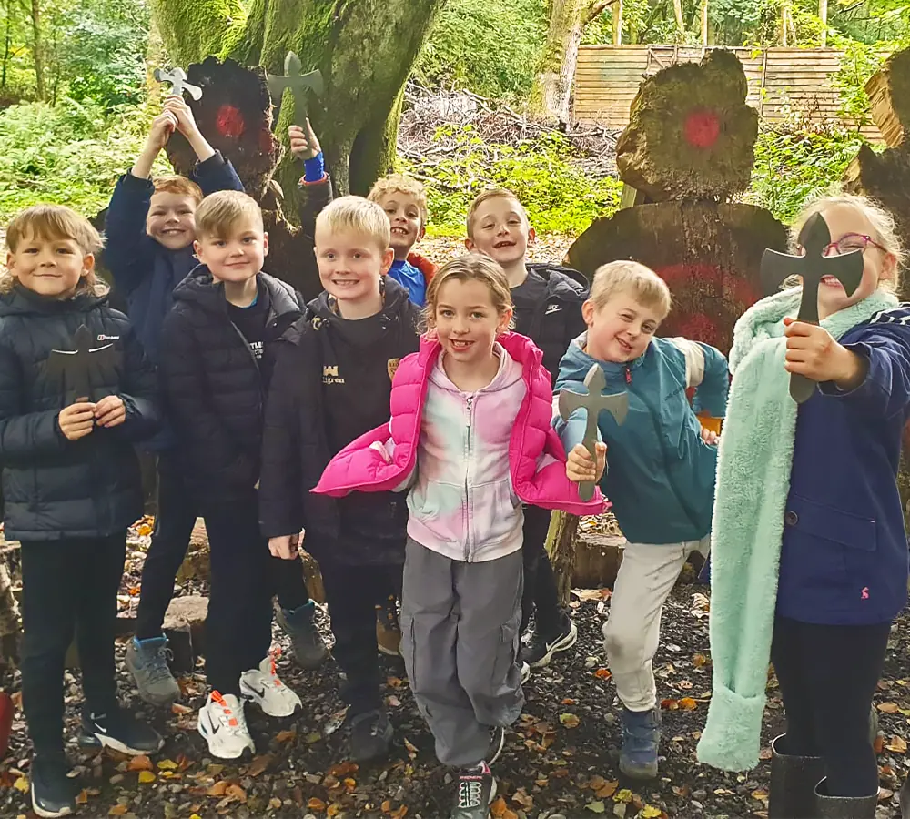 Kids party doing knife/angel throwing, taking a group photo in front of outdoor knife targets