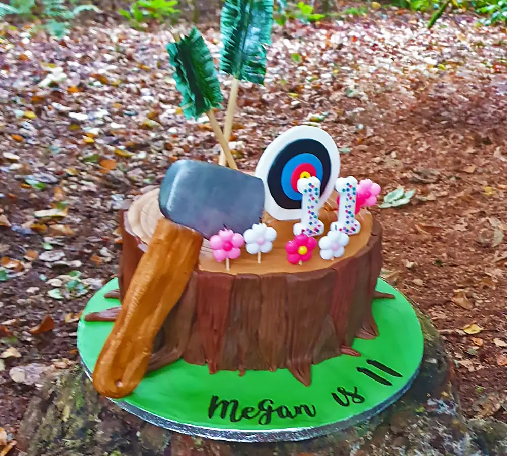 Child's birthday cake with a throwing axe, arrows and an archery target as decorations