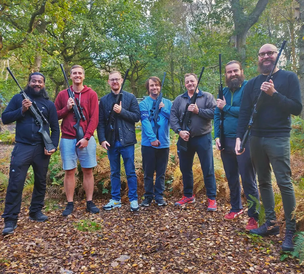 Stag party posing with air rifles after shooting them on their stag party at Adventure Now Manchester