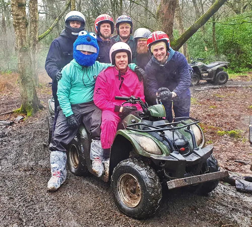 Small stag group all together on a quad bike. The stag is in the middle wearing a pink outfit